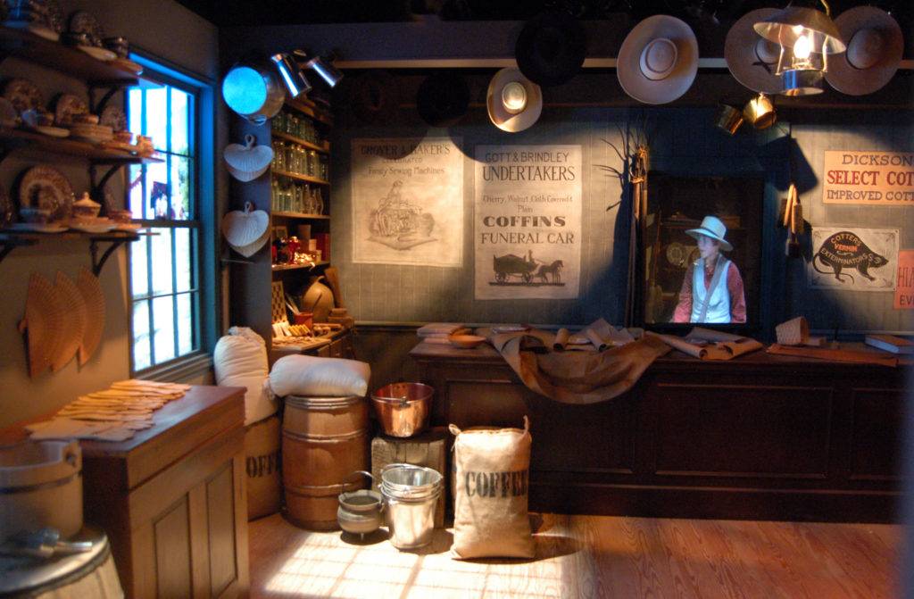 Old-timey general store, with sacks, barrels, straw hats, and a holographic boy behind the counter