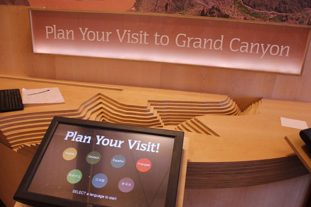 Touch screen display saying "Plan Your Visit!" and "SELECT a language to start"