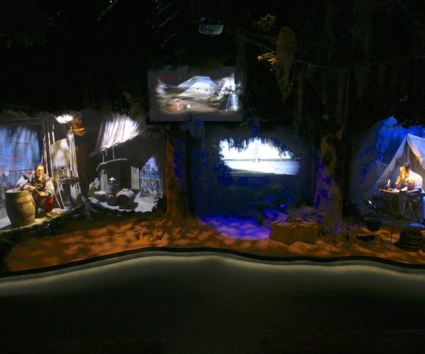 Immersive pirate-themed theater with life-sized models, screens, and theatrical lighting