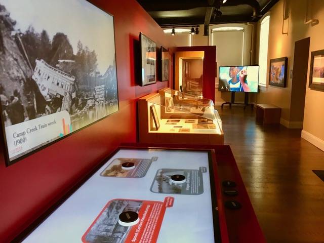 Touch-Table Interactive alongside an exhibit of encased photos