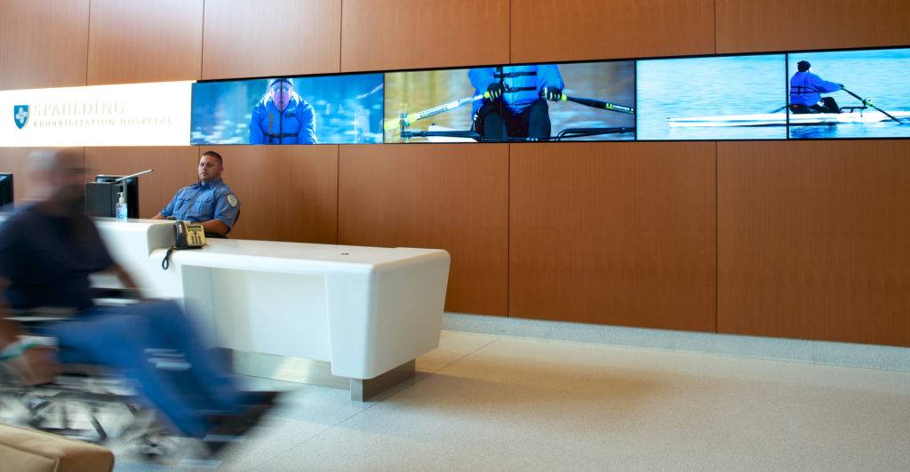 Long multiscreen display of woman rowing in the Spaulding lobby