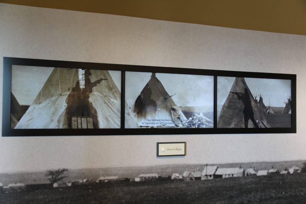 Three-screen film of a battle on a Native American settlement