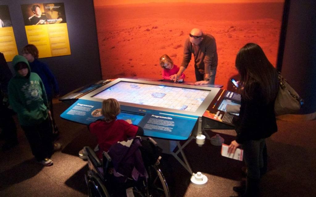Visitors surrounding an interactive touch-table