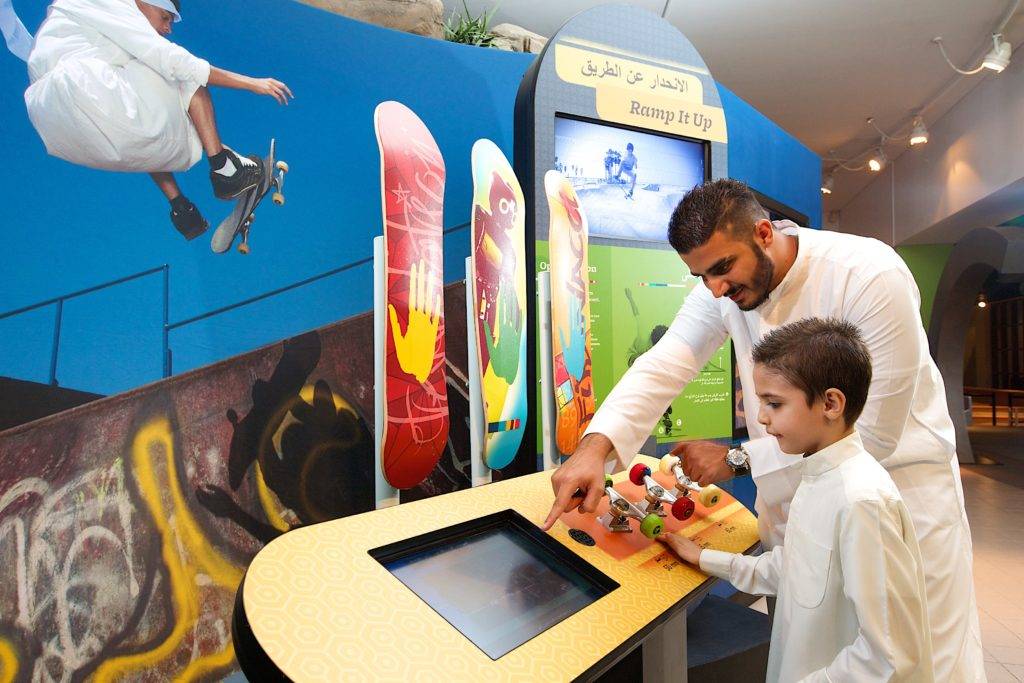 Father and son in in Dubai engaging with a skateboarding interactive