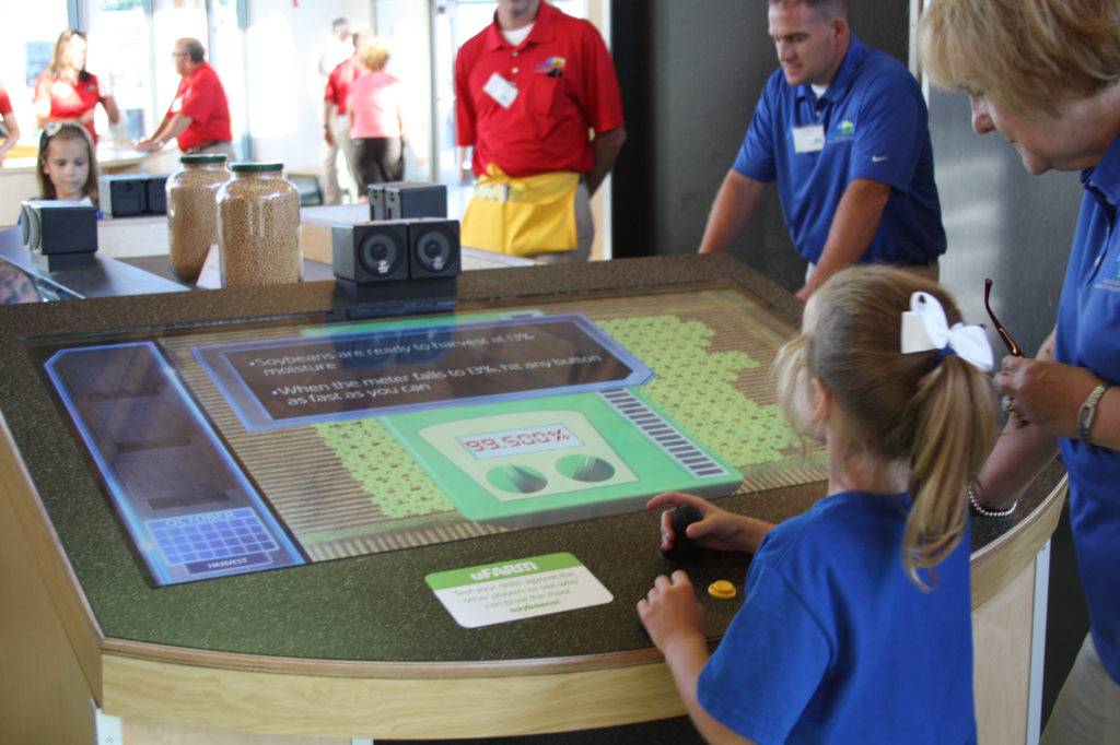 Visitors and staff gathered around an interactive touch-table
