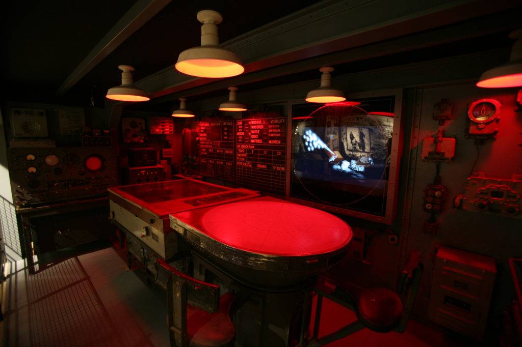 Immersive exhibit inside a dimly lit ship control room