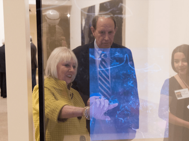 Visitors engaging with a see-through glass touch interactive at the Art Museum of South Texas
